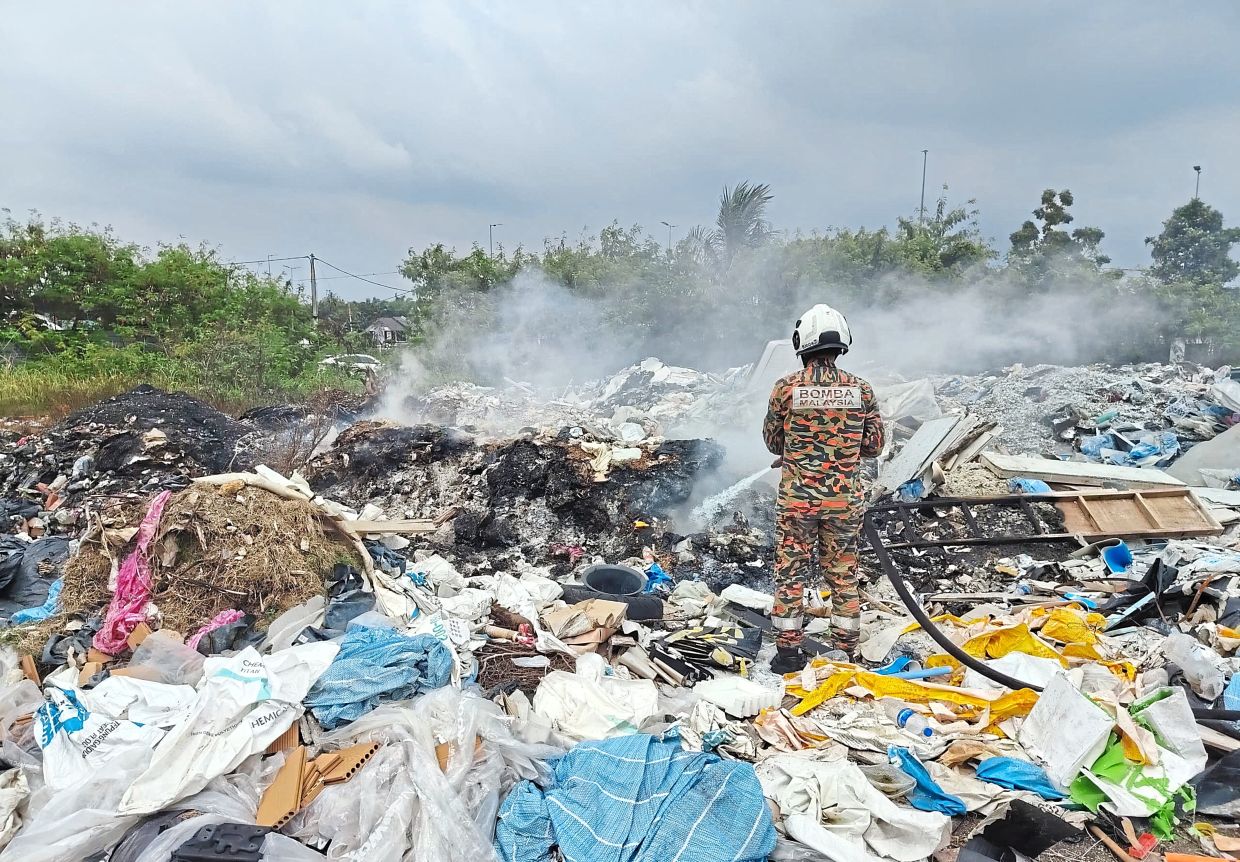 Firefighters working to extinguish a blaze at a site near the Jalan Sijangkang Utama–Jalan Kebun Tambahan intersection.