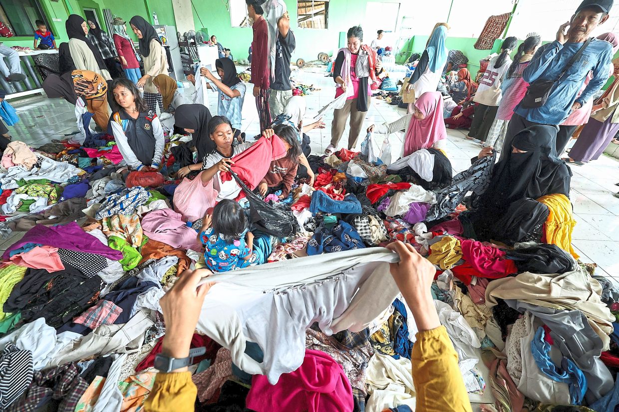 Picking up the pieces: Kampung Bahagia fire victims searching through used clothes donated by members of the public. — Bernama