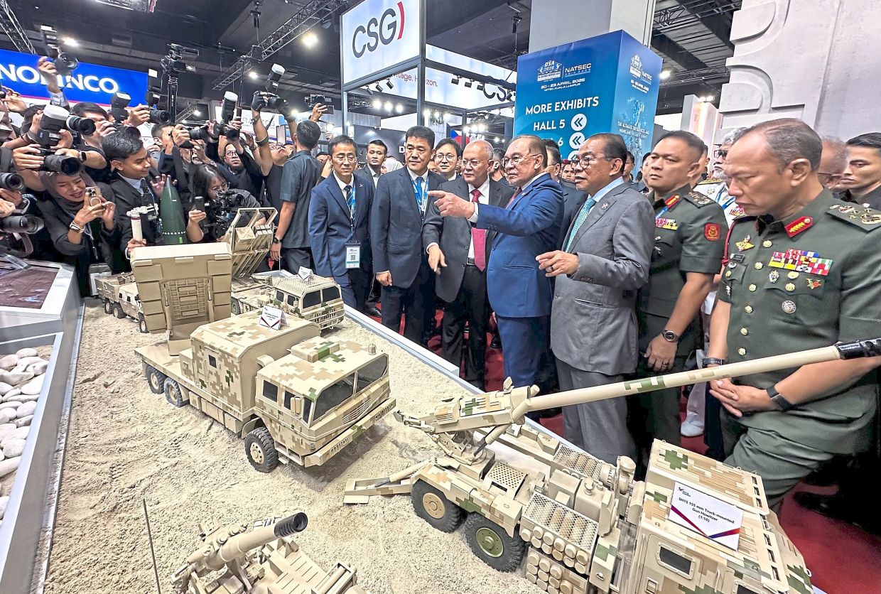 In command: Anwar pointing at miniature models of military vehicles on display during a walkabout at the Defence Services Asia and Natsec Asia 2026 exhibitions at Mitec, Kuala Lumpur. — RAJA FAISAL HISHAN/The Star