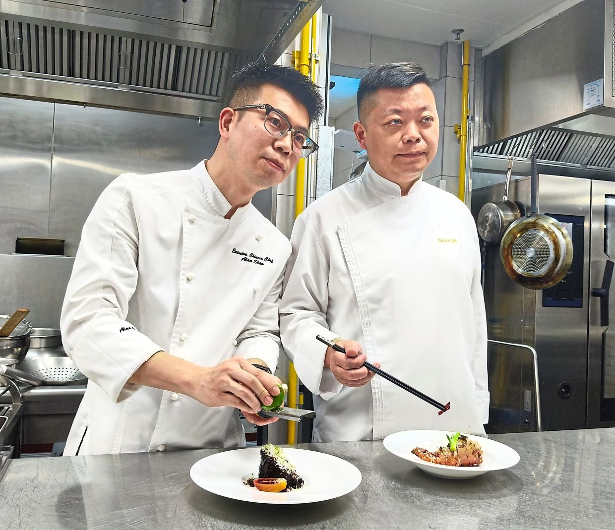 Shao (left) and Yu plating two of the dishes servedduring dinner at China House.