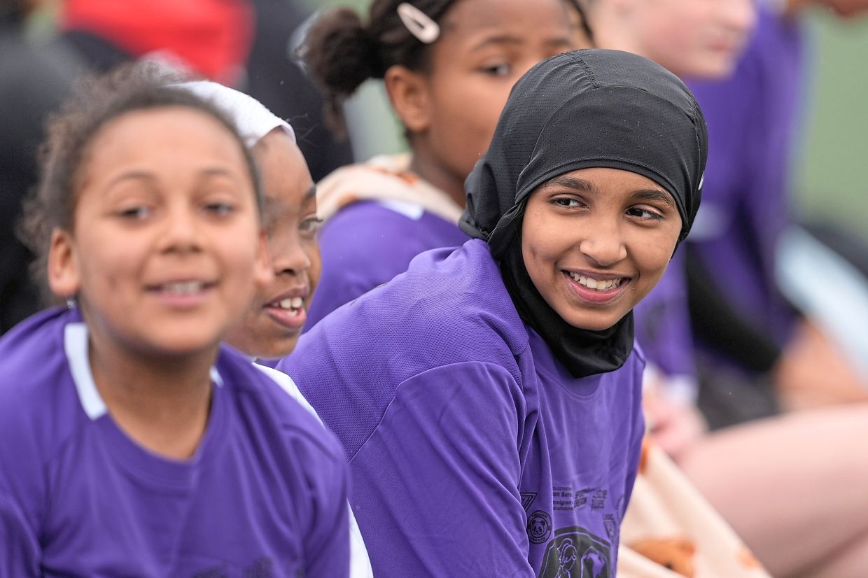 Amina Mohamed (right) sits with teammates during a soccer tournament.