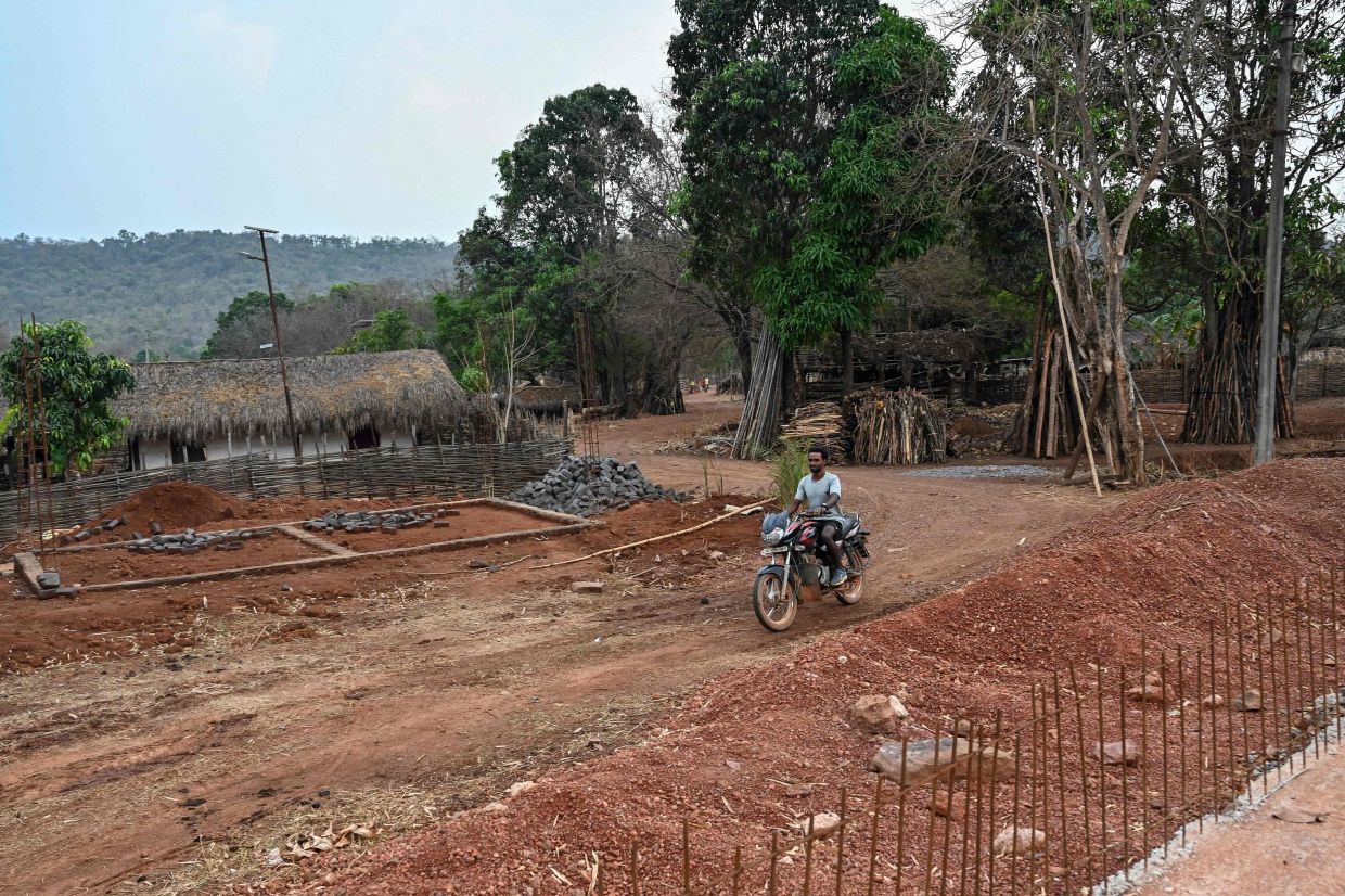 A motorcyclist riding across an under-construction road at Mohandi village in Chhattisgarh's Narayanpur district. - AFP
