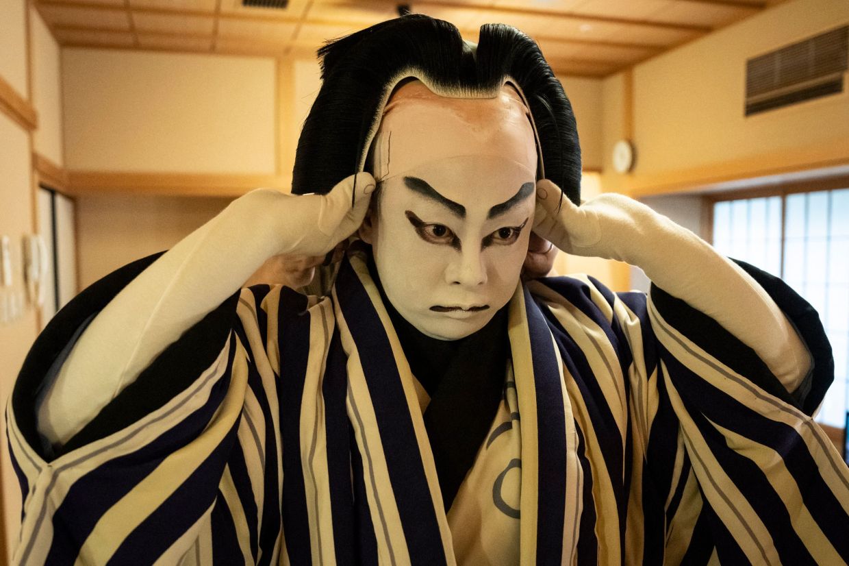 Kabuki wig master Tadashi Kamoji (not pictured) helping kabuki actor Tanenosuke Nakamura to put on his wig before his performance at the Kabuki-za Theatre in Tokyo. - AFP