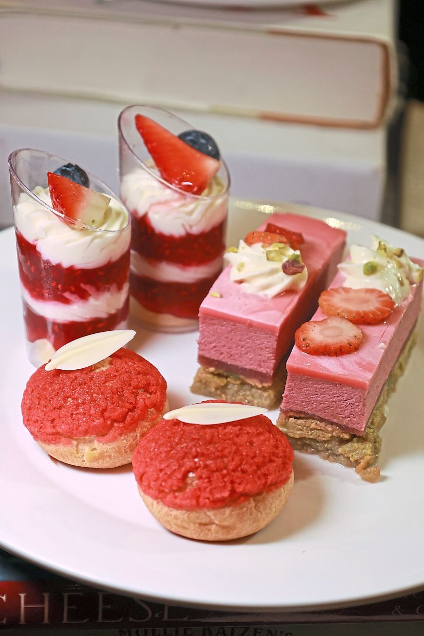 Clockwise from top left: Strawberry white chocolate trifle, pistachio strawberry gateaux and strawberry rose profiteroles. — Photos: KAMARUL ARIFFIN/The Star 
