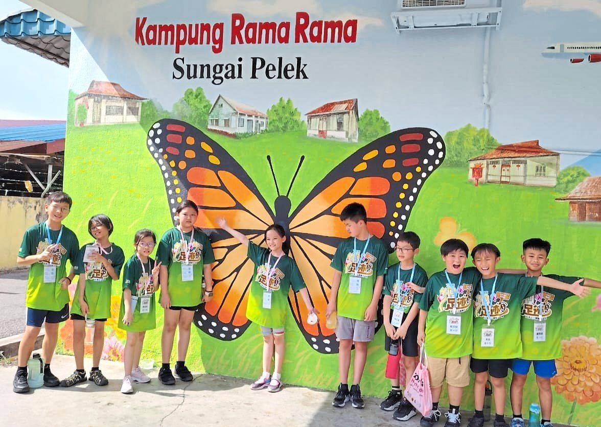 School children visiting the butterfly mural at Sungai Pelek new village.