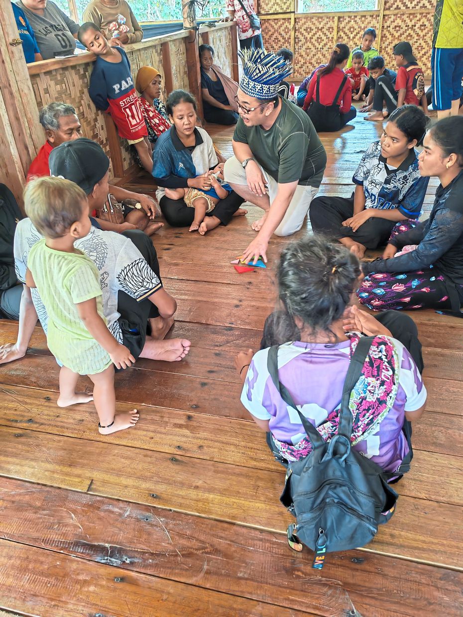 Khoo (middle) with Pos Lanai Orang Asli community during one of the sessions to spread the awareness of sustainable tourism.