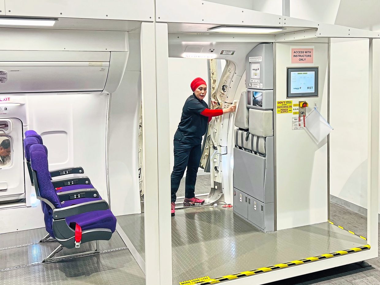 Rachel demonstrating how to open the door during the door drill. — GISELE SOO/The Star