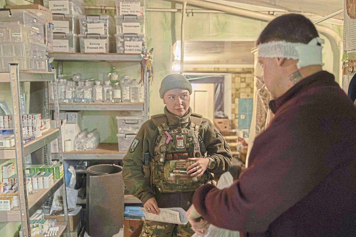 Podobailo attending to an injured soldier at her station, before sending him off to a hospital.