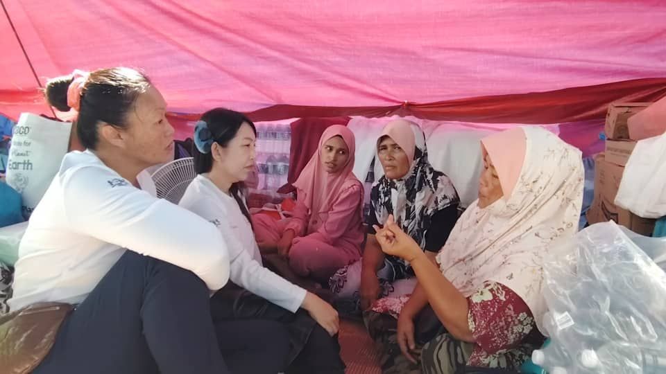(second left) Elain speaking to some fire victims.