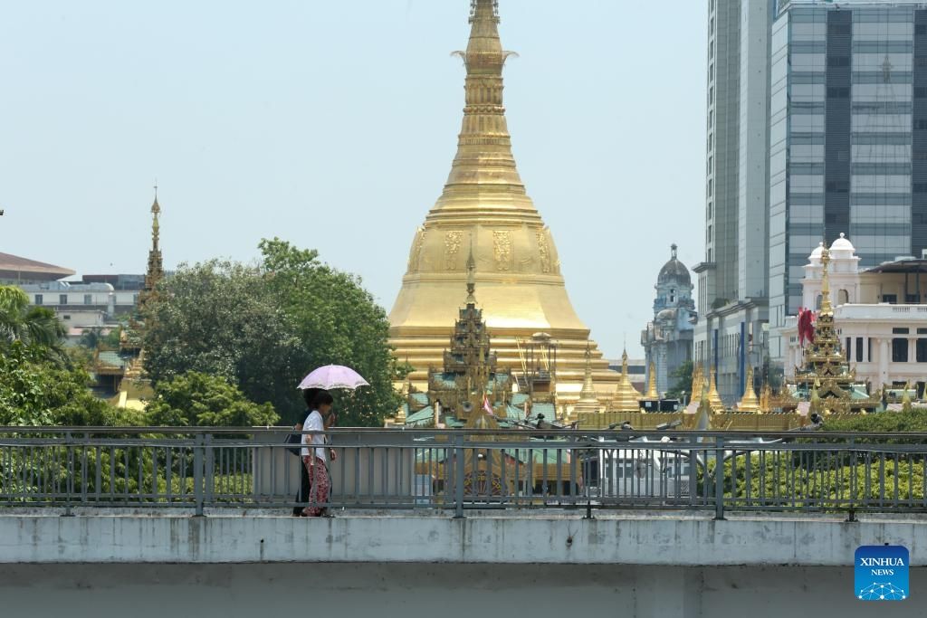 Pedestrians shield themselves from the sun with an umbrella in Yangon, Myanmar, April 22, 2026. - Photo: Xinhua
