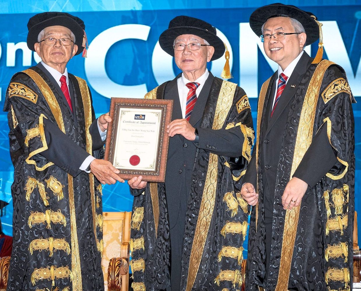 Installation: Ting (far left) presenting the certificate of appointment to Wong, as Prof Ewe (far right) looks on.