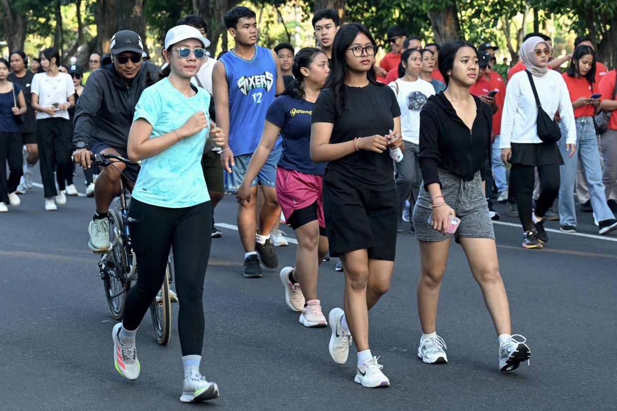People walk during a Car Free Day (CFD) along the main road at the Renon district in Denpasar, Indonesia's resort island of Bali, on Sunday, April 26, 2026. -- Photo by SONNY TUMBELAKA / AFP