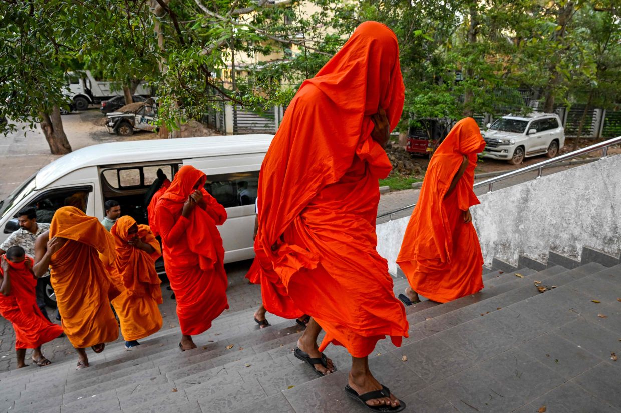 Sri Lankan monks arrive to appear before a court after their arrest in Negombo on April 26, 2026. Twenty-two Sri Lankan monks returning from Thailand were arrested on Sunday, April 26, 2026, at the main international airport with 110 kilograms (242 pounds) of powerful cannabis, officials said. -- Photo by Ishara S. KODIKARA / AFP
