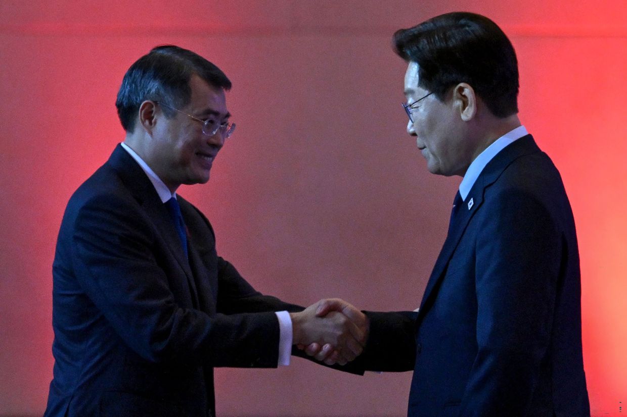 Vietnam's Prime Minister Le Minh Hung (left) shakes hands with South Korean President Lee Jae-myung at the Vietnam-South Korea business forum in Hanoi. -- Photo by Nhac NGUYEN / AFP