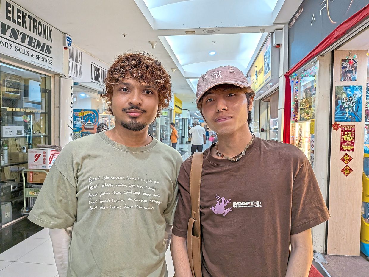 For Afiq (right) and Harith, physical media acts as a tangible reminder of events in their lives in a way that digital files cannot. — CHRISTOPHER FAM/The Star