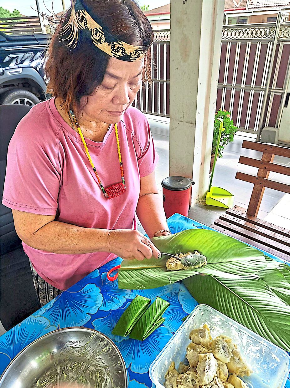 Jessy wrapping durian flesh in a leaf locally known as ‘daun sip’.