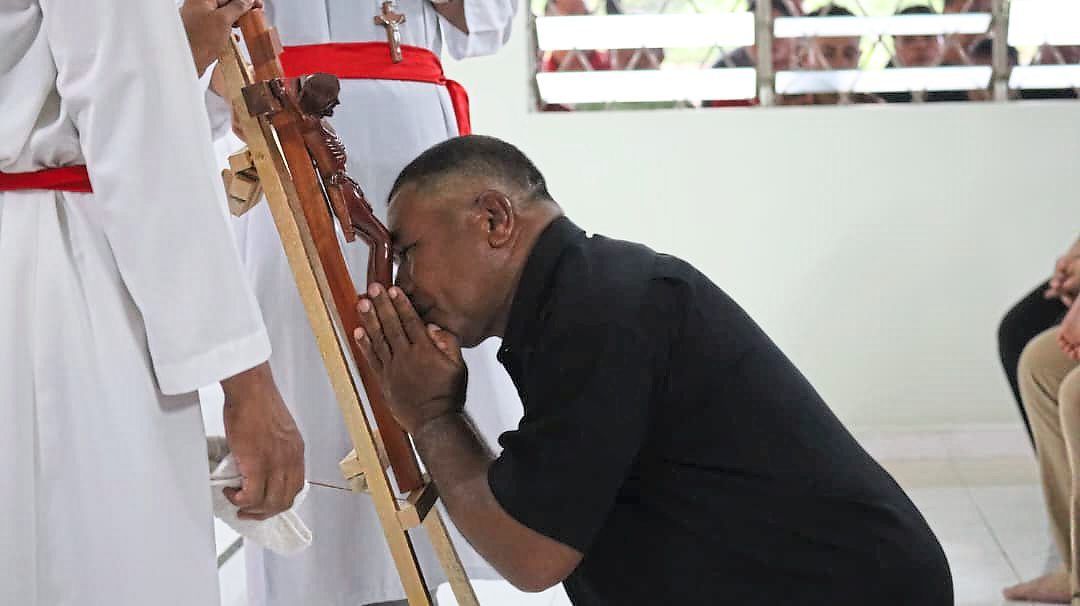 A man kisses the cross as part of the Good Friday observance.