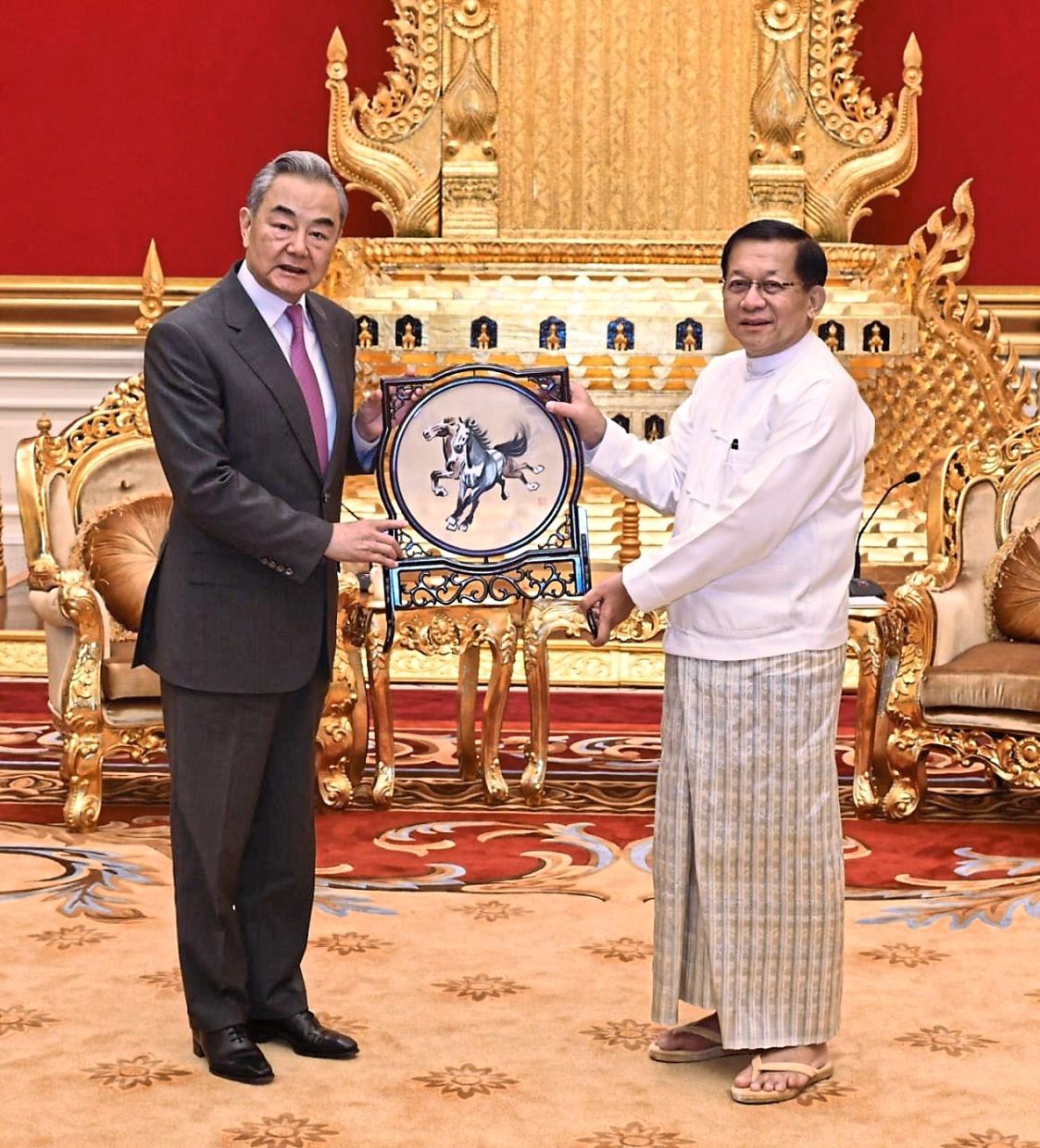 Strategic diplomacy: Min Aung Hlaing (right) receiving a gift from Wang Yi during their meeting in Naypyidaw. — Myanmar Military True News Information Team/AP 