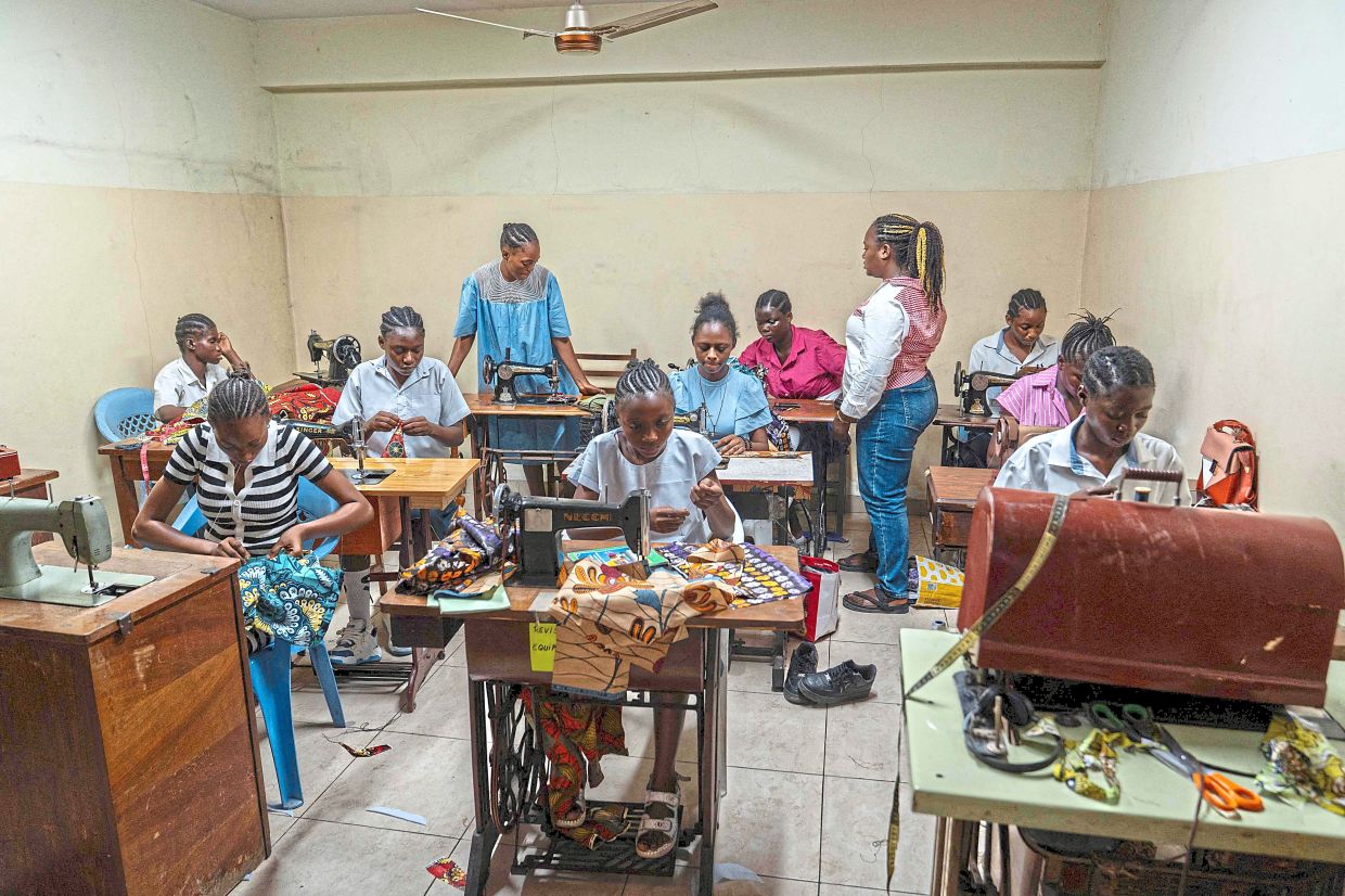 Girls who have been taken off the streets learning to cut and sew at the training centre of the NGO, Oseper, in Kinshasa. — AFP
