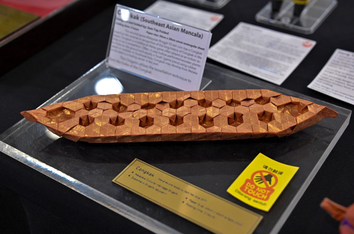 A congkak board, made with paper.