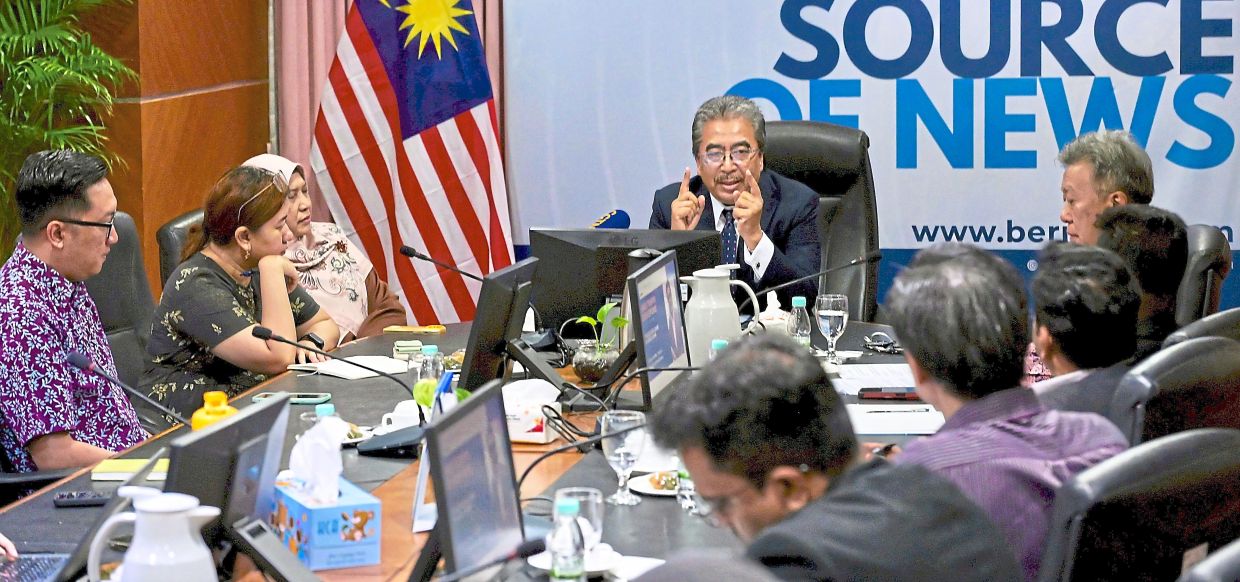 Powering on: Johari (centre) speaking at the Concorde Club meeting in Kuala Lumpur. In attendance are The Star assistant news editor Rahimy Rahim (left) and Wong (right). — RAJA FAISAL HISHAN/The Star