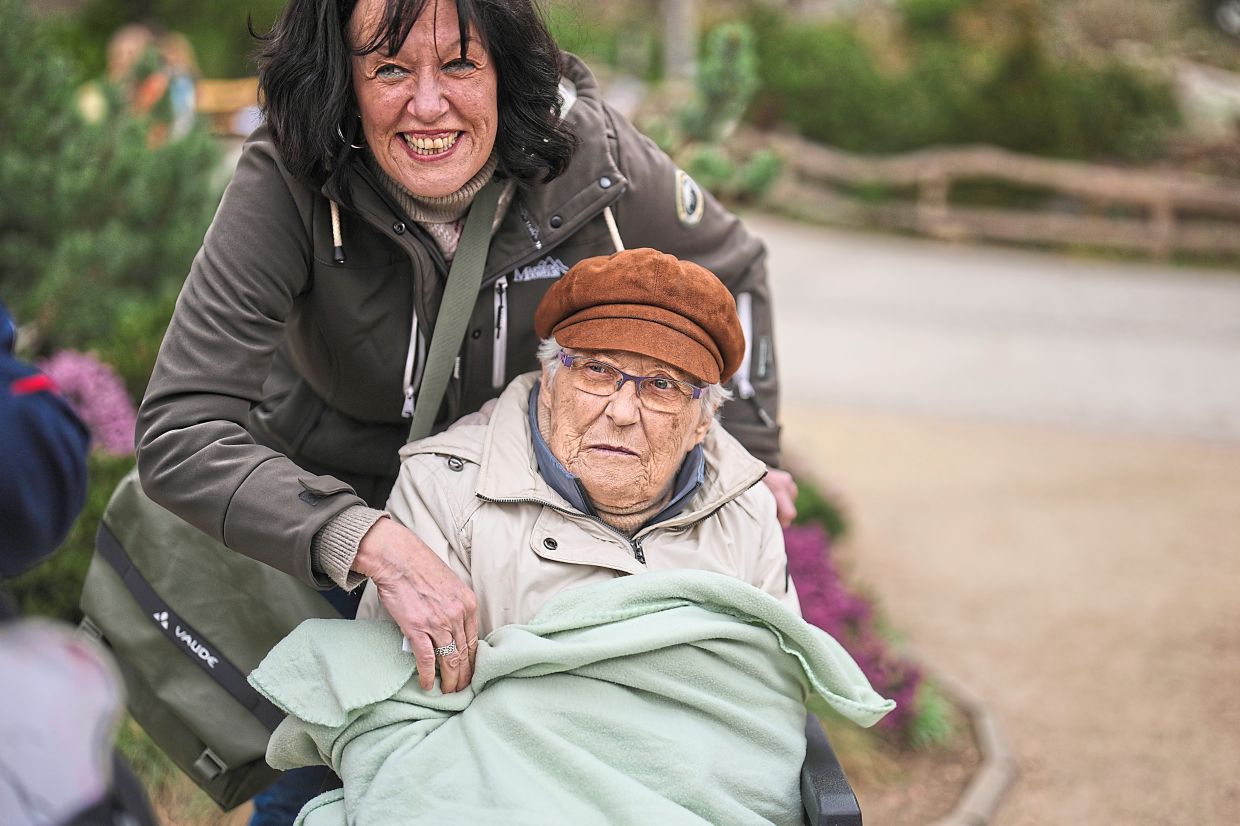 Barkow (left) is wrapped in a blanket by her daughter Grudda during a guided tour for people with dementia. Photo: AP