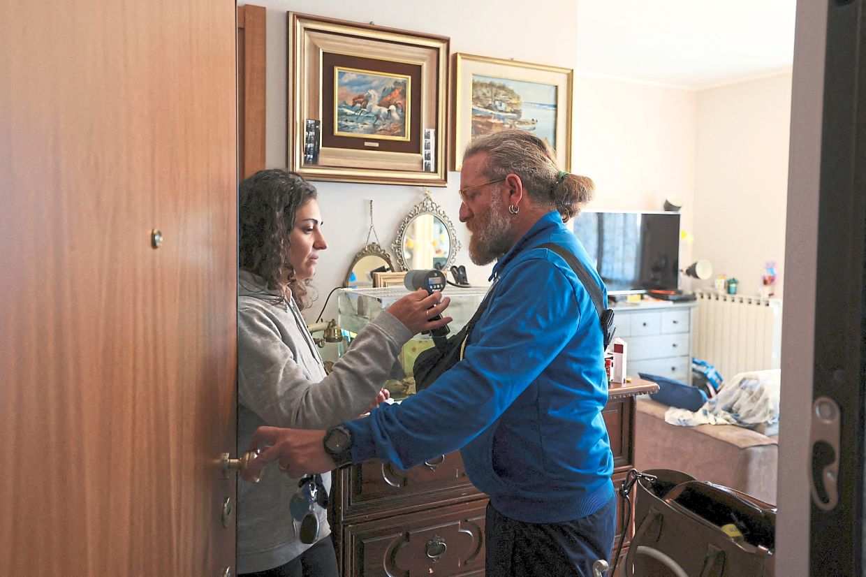 Di Franco (left) and Nugnes exchange car keys, as Di Franco takes their son Enrico to football training. Photo: Reuters