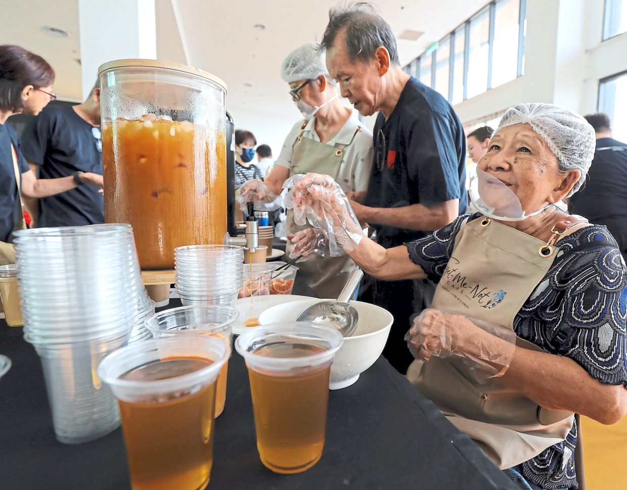 Saw (right) happily prepares drinks for diners. Photo: The Star/Azlina Abdullah