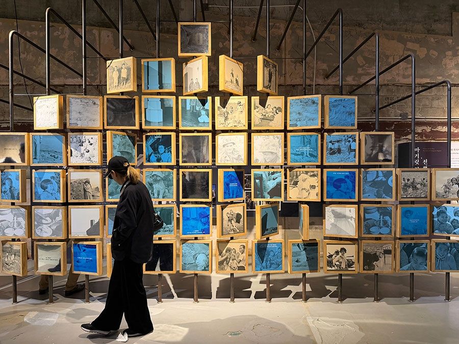 The weight of memory: A visitor explores an installation at Gallery Greaves, where individual snapshots piece together the human stories of a nation’s interrupted peace. -- PHOTO: THE STAR / Asia News Network