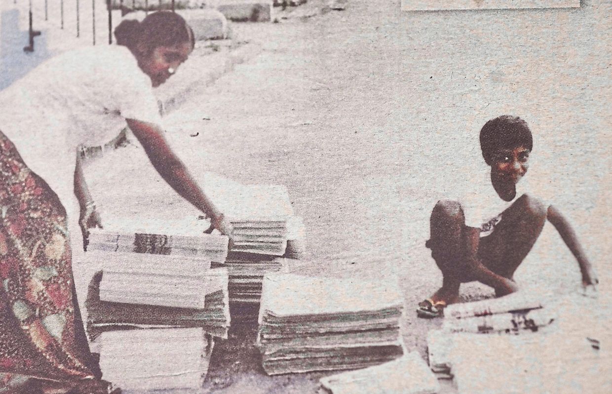 A young Saravanan with Danapackiam, sorting stacks of newspapers in the early hours. Photo: Saravanan Manickam