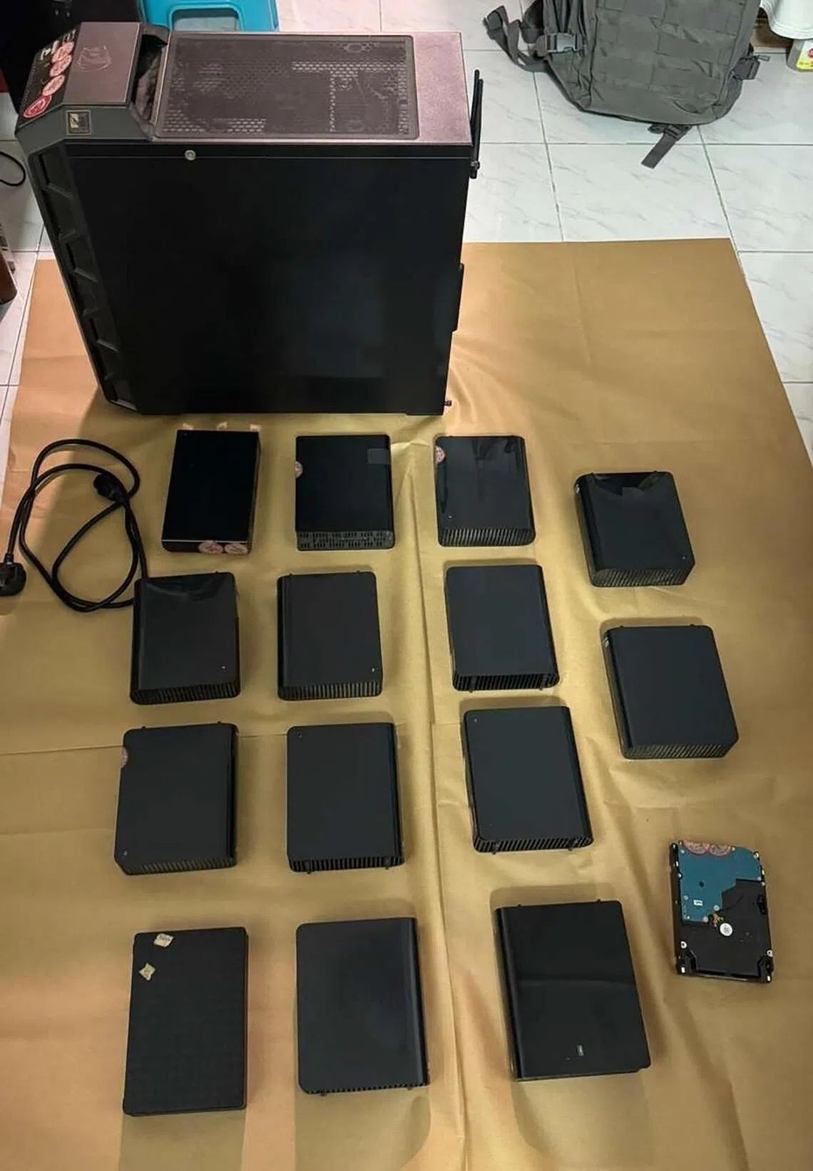 Police officers seized 116 computers, 340 mobile phones, 25 tablets, 140 storage devices and 16 routers, including child sexual abuse materials and obscene materials. - Photo: SINGAPORE POLICE FORCE