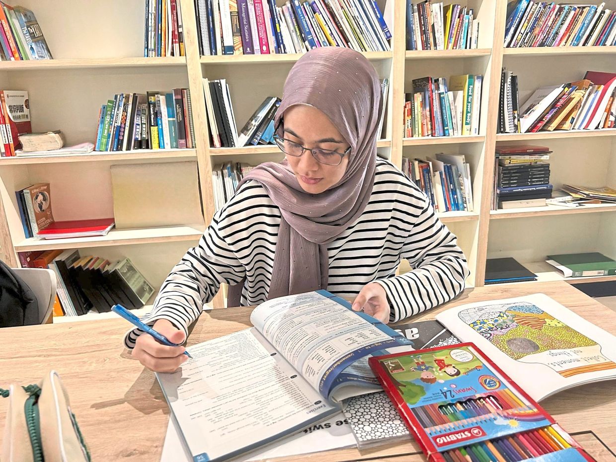 Raudhatul Husna preparing lesson plans before her tutoring session.