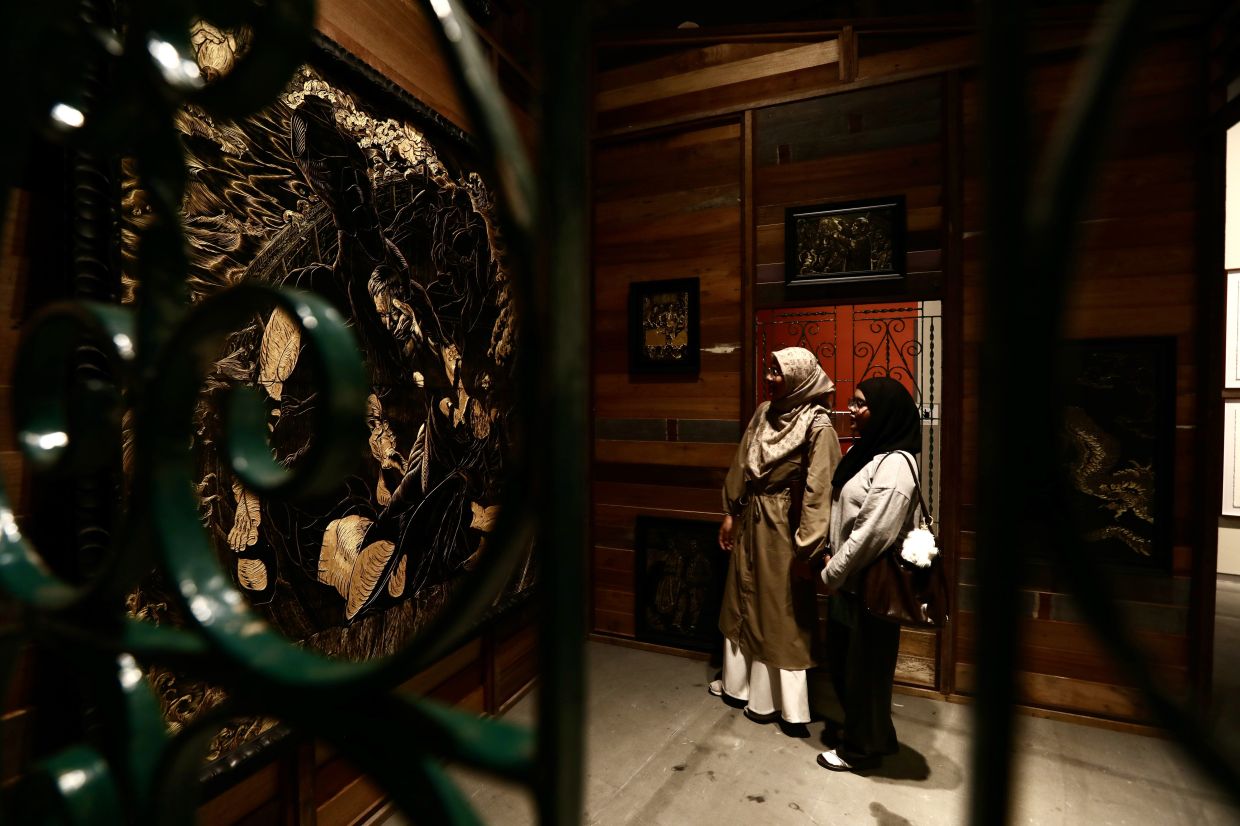 A view of Gan Chin Lee's 'Invasion And Resistance' (lacquer carving on MDF board, wooden house structure, 2025) installation at the 'Ilham Art Show 2025' at Ilham Gallery, Kuala Lumpur. Photo: Low Lay Phon/The Star 