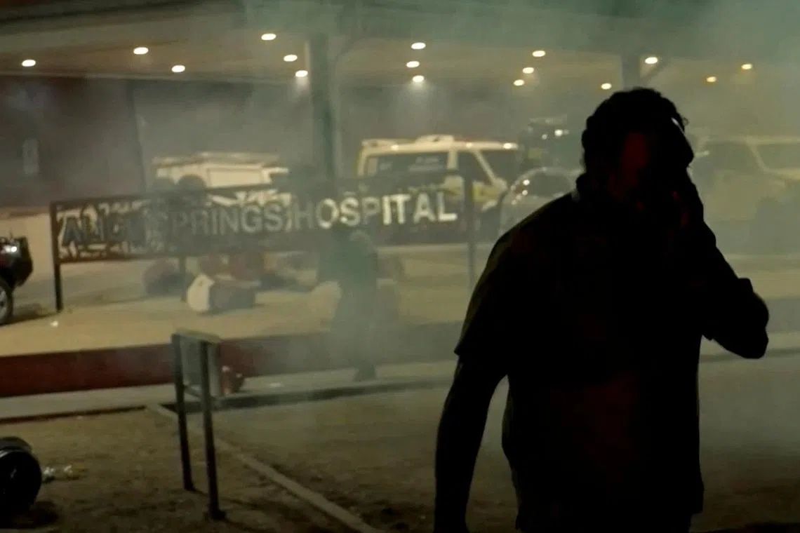 A man walks amidst tear gas during community unrest outside Alice Springs Hospital, where a 47-year-old man arrested in connection with the alleged killing of five-year-old Kumanjayi Little Baby was taken, in Alice Springs, Australia, April 30, 2026, in this screengrab taken from a video. - Photo: AUSTRALIAN BROADCASTING CORPORATION/via Reuters