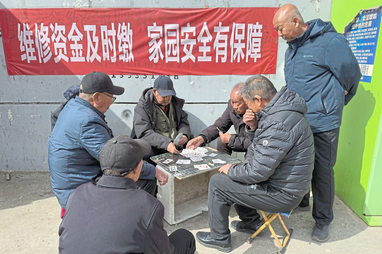 Elderly men playing cards at a residential complex for former and current coal miners in Datong. — AP