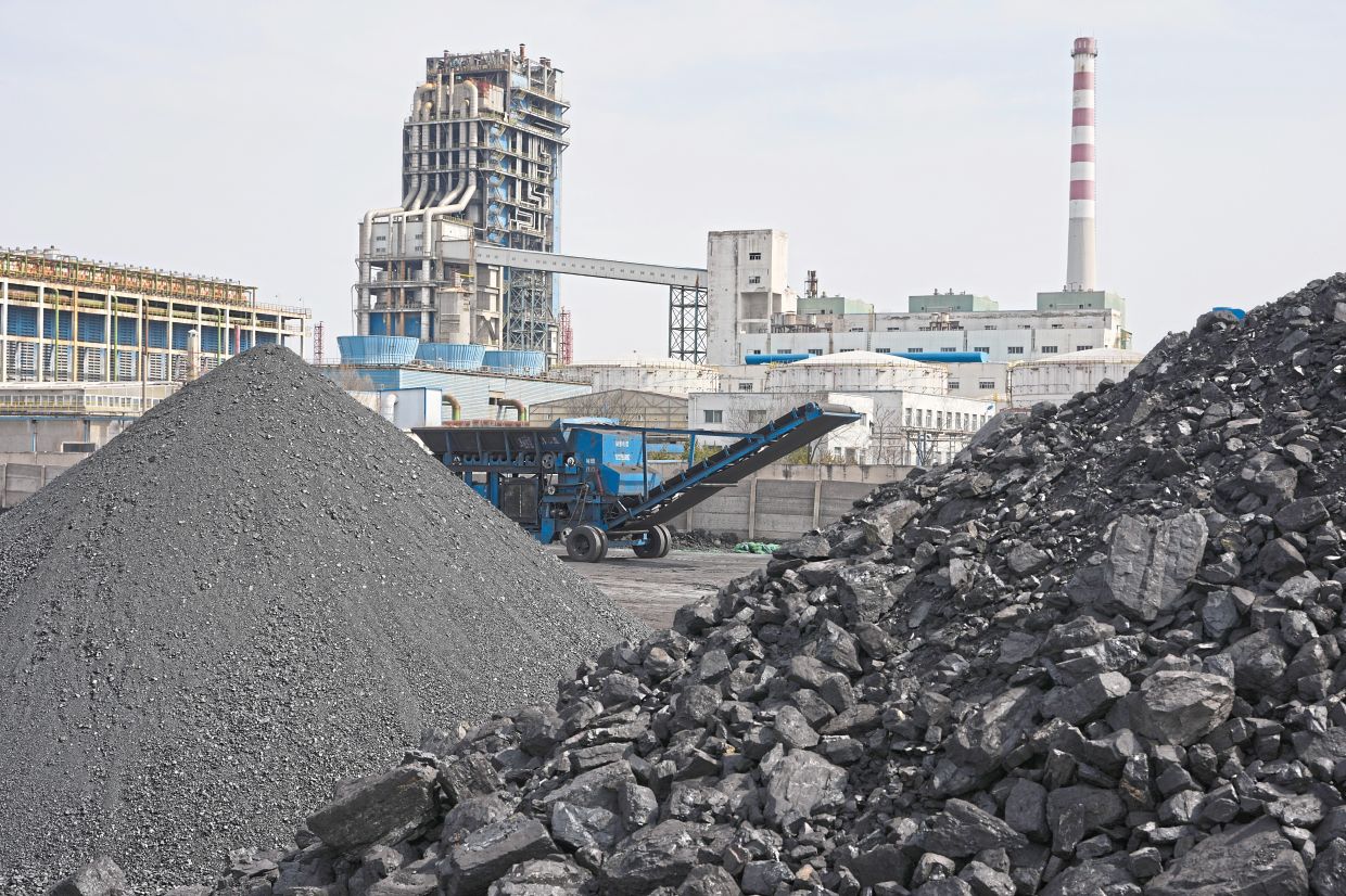 Piles of coal sitting near a chemical plant in Datong. — AP