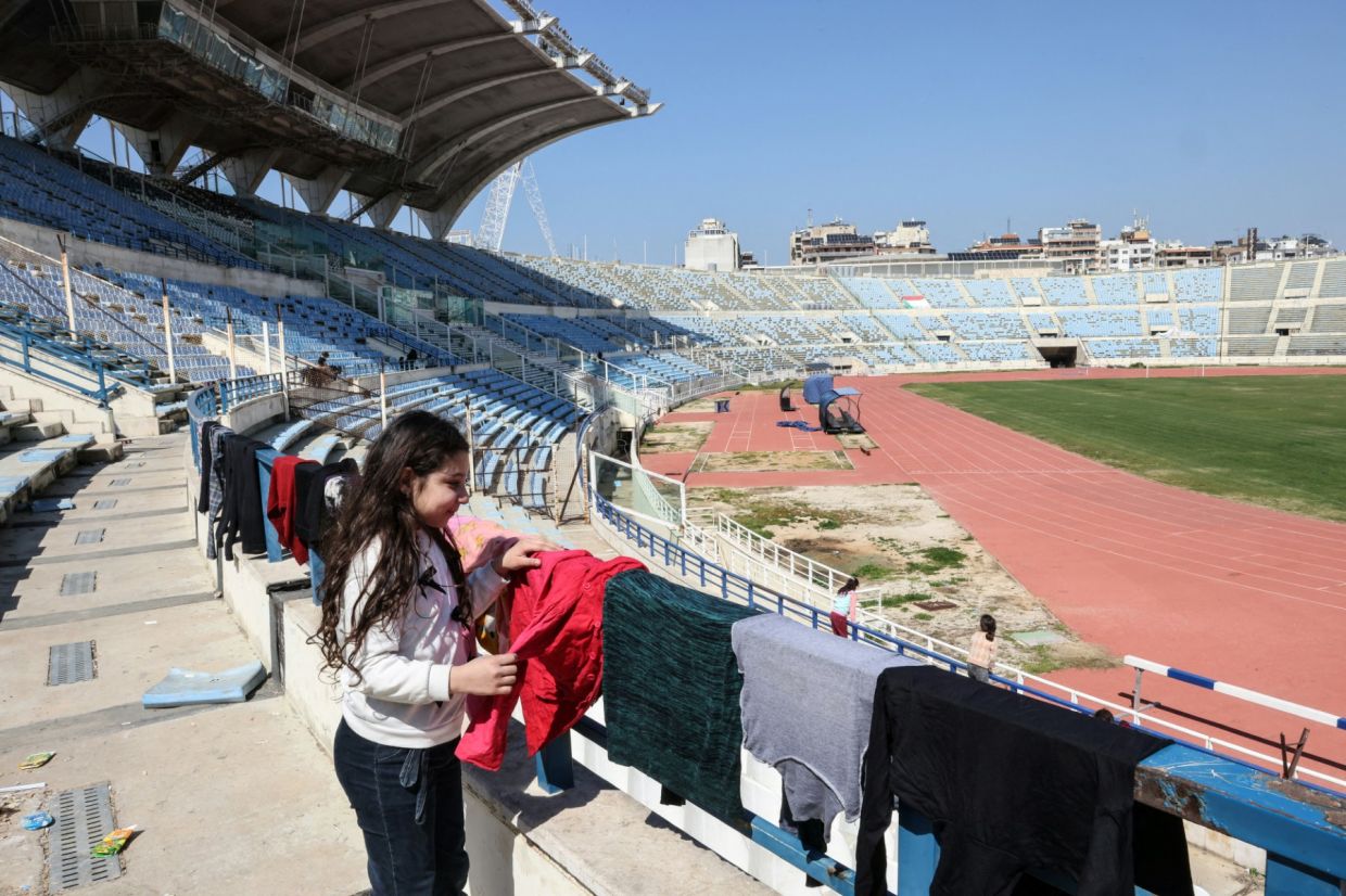 A displaced girl hanging her laundry to dry on the stands at the Camille Chamoun Sports City stadium, which was converted into a shelter facility for those displaced by the US-Israel war on Iran. — AFP