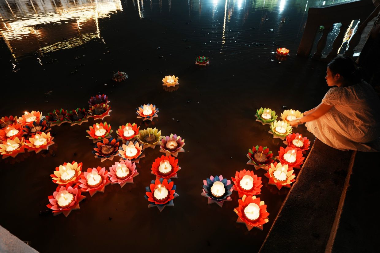 A Cambodian girl floats candle lights in a pond during marking the Buddhist Visak Bochea at Wat Phneat Sampily outside Phnom Penh, Cambodia. -- AP Photo/Heng Sinith