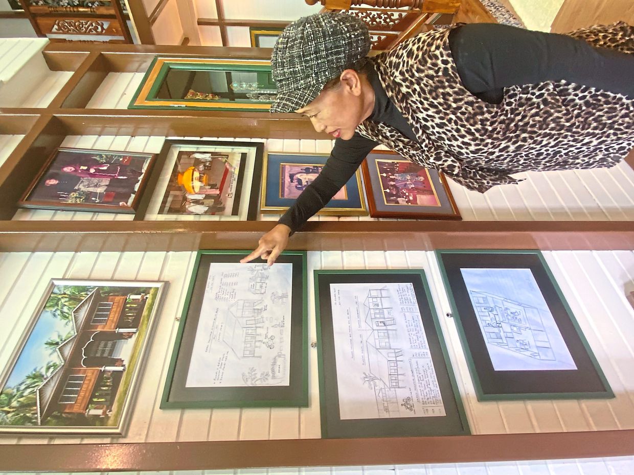 Noripah looking at sketches of the old ancestral home on display at Tanah Embah Heritage 1939.