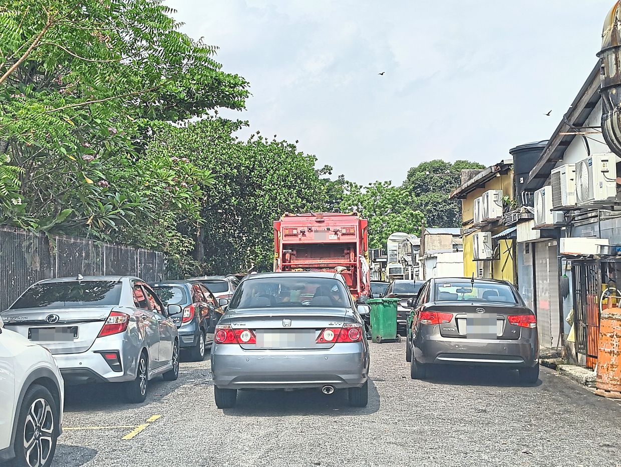 Motorists parking illegally on the right of the back lane behind the shophouses on Jalan 11/4, making it difficult for waste collection lorries to go through.