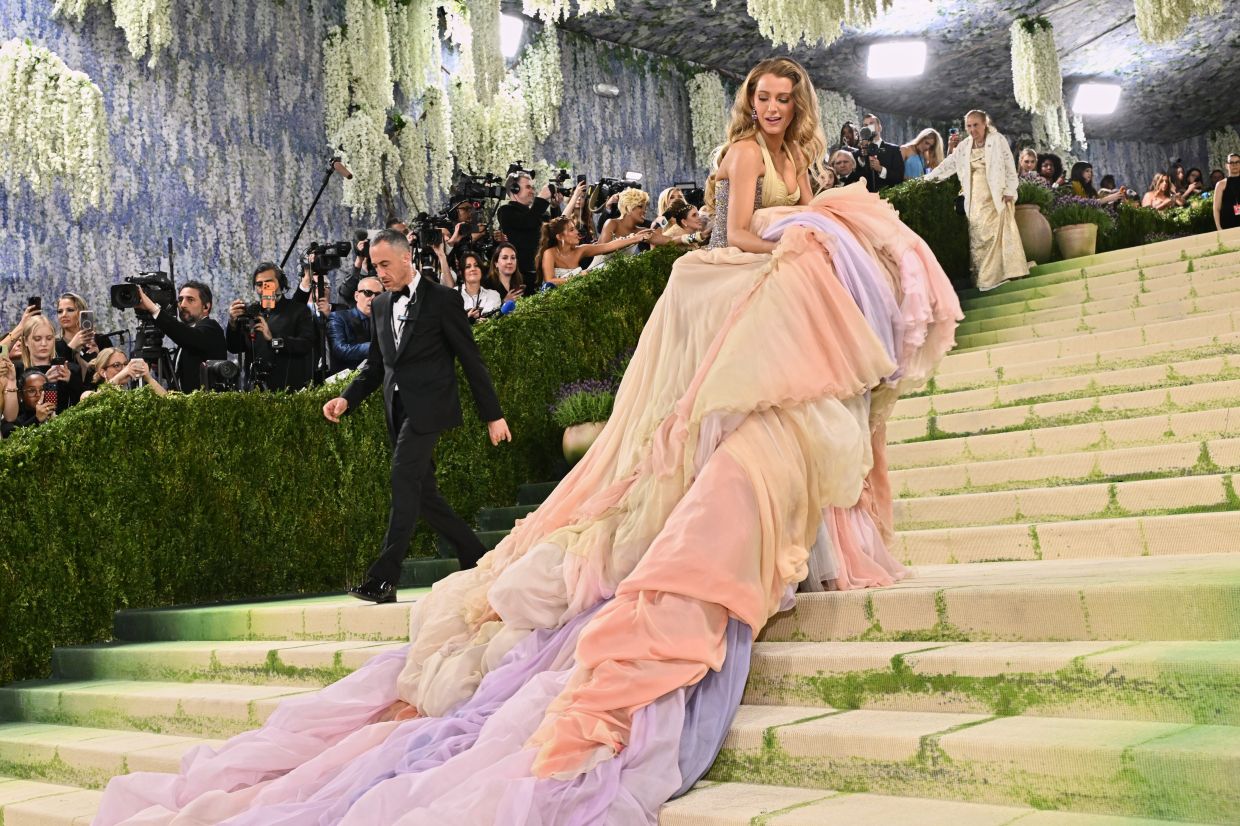 Blake Lively adjusting her long dress on the steps to The Metropolitan Museum of Art's Costume Institute benefit gala. Photo: AP