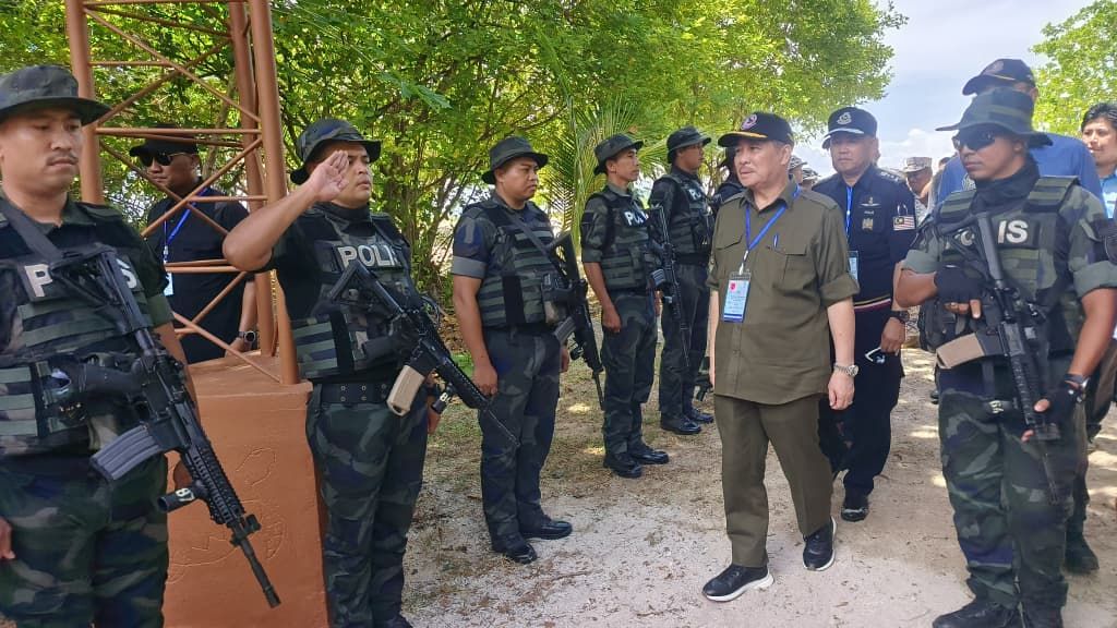 Hajiji (centre) inspects personnel on duty during his visit to Pulau Langkayan as part of a security assessment in Sabah’s east coast waters.
