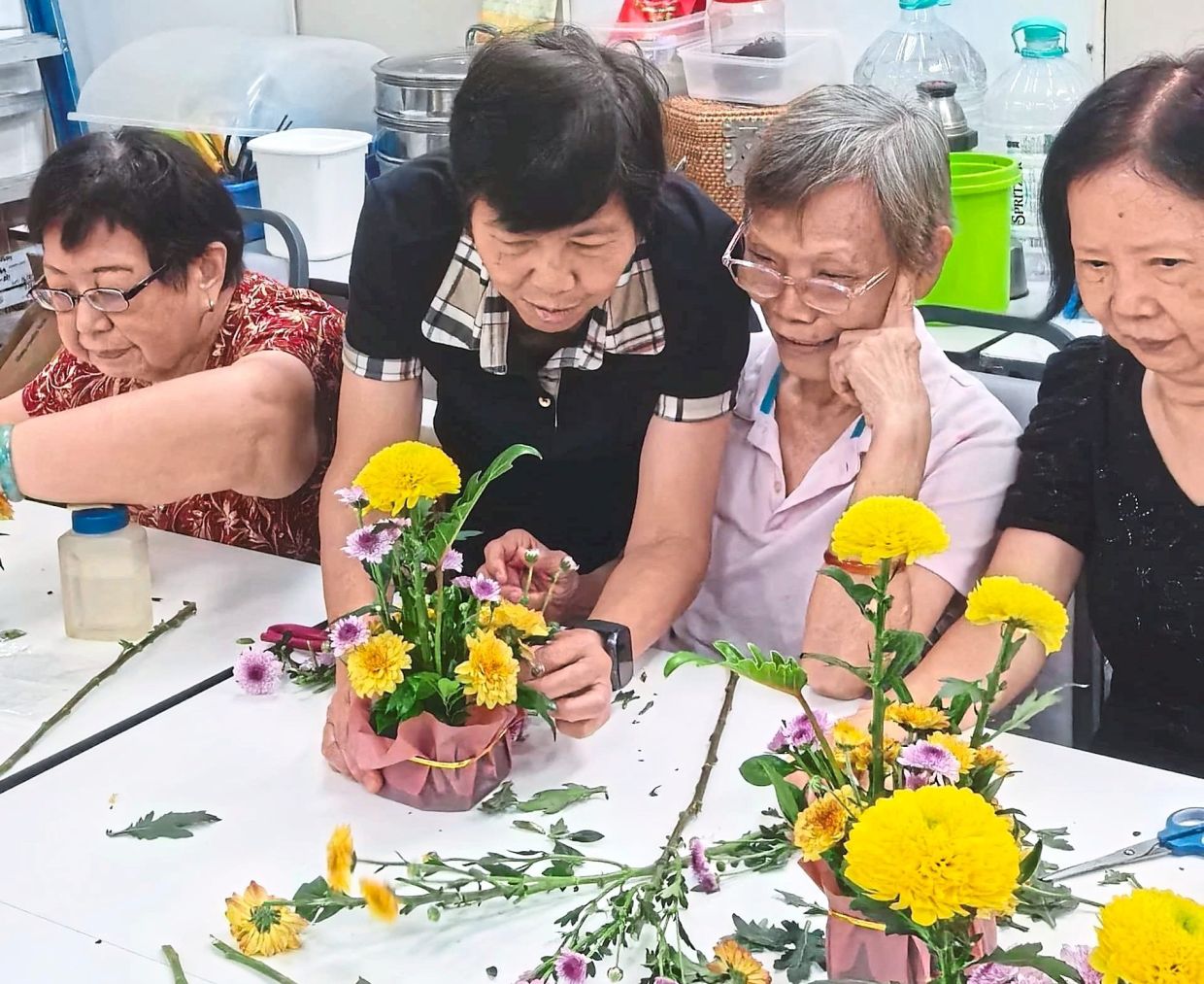 Tan patiently instructing participants on methods to best arrange flowers. — Photos: Handout