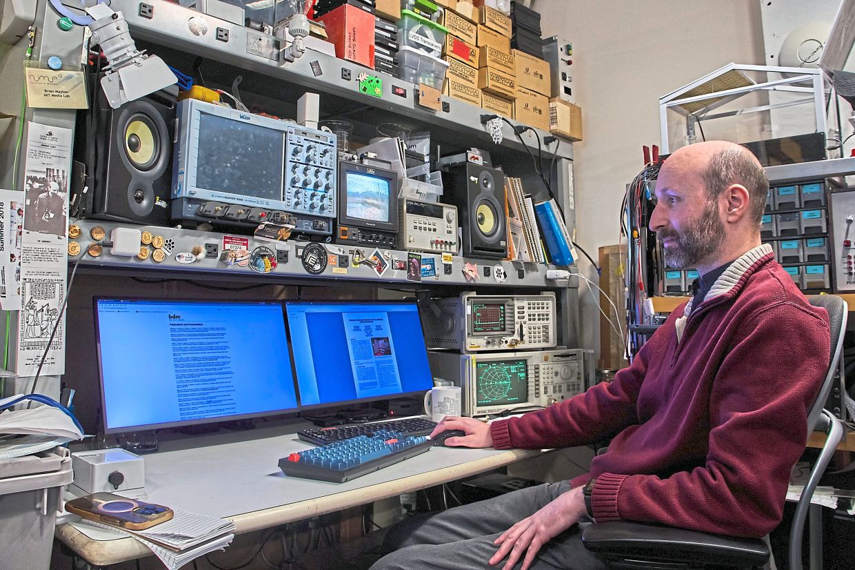 Brian Mayton, a member of the Living Observatory and research affiliate at Massachusetts Institute of Technology Media Lab, reads research papers at his desk at MIT.