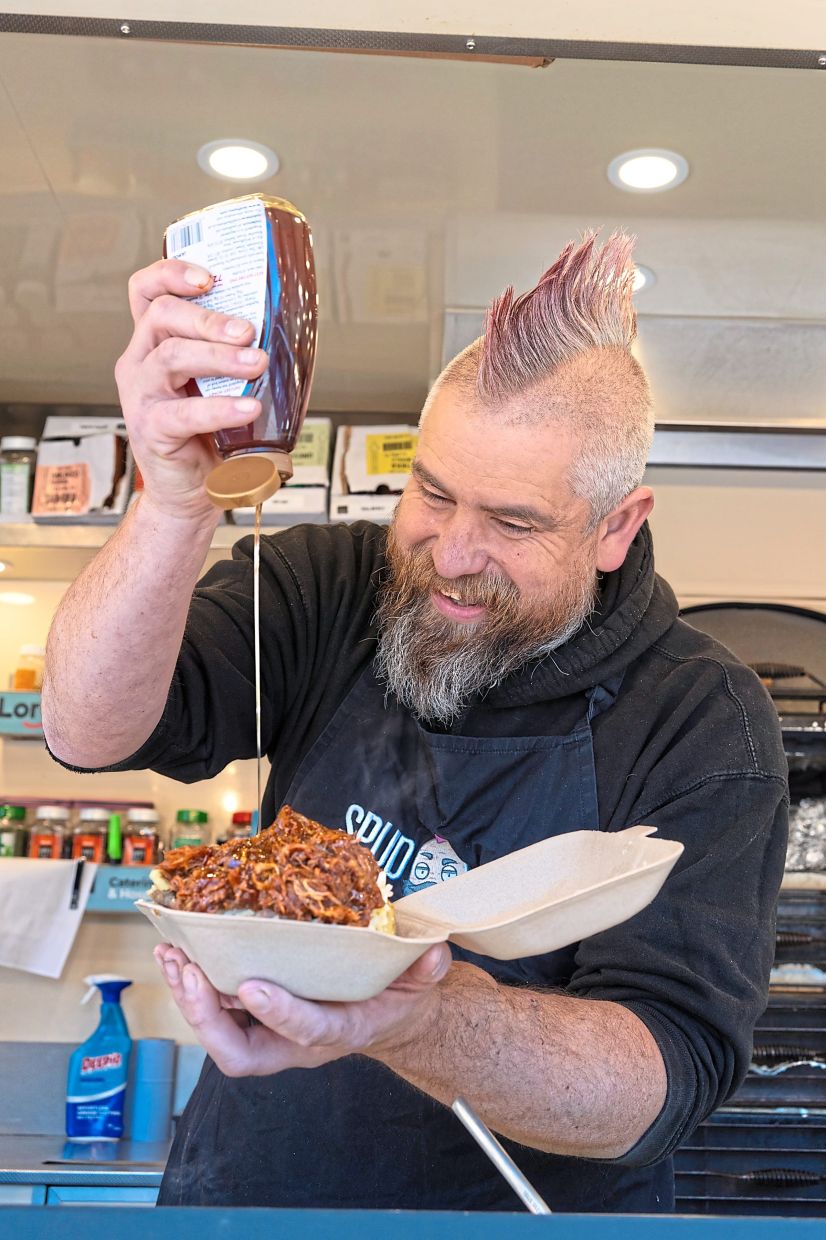 Newman, who is known as Spudman both behind the counter and on social media, prepares a jacket potato. — CHIARA LUXARDO/The New York Times