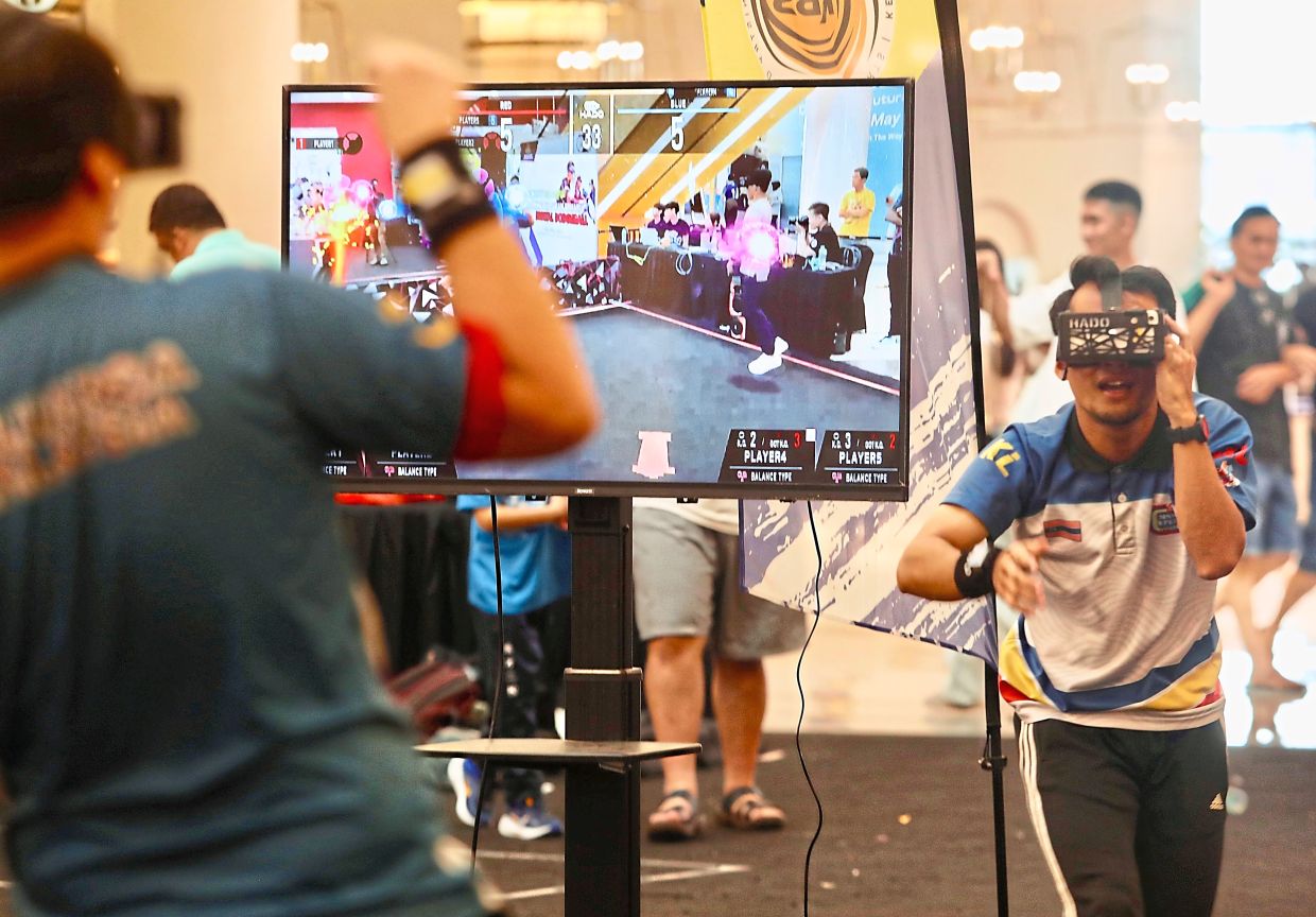 Teams battling it out at the digital dodgeball mini tournament where a screen shows players tossing coloured “digital balls” at their opponents.