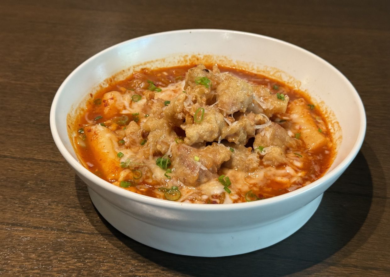 Fried chicken, melted cheese and chewy rice cakes form the structural underpinnings of this decadent dish. 