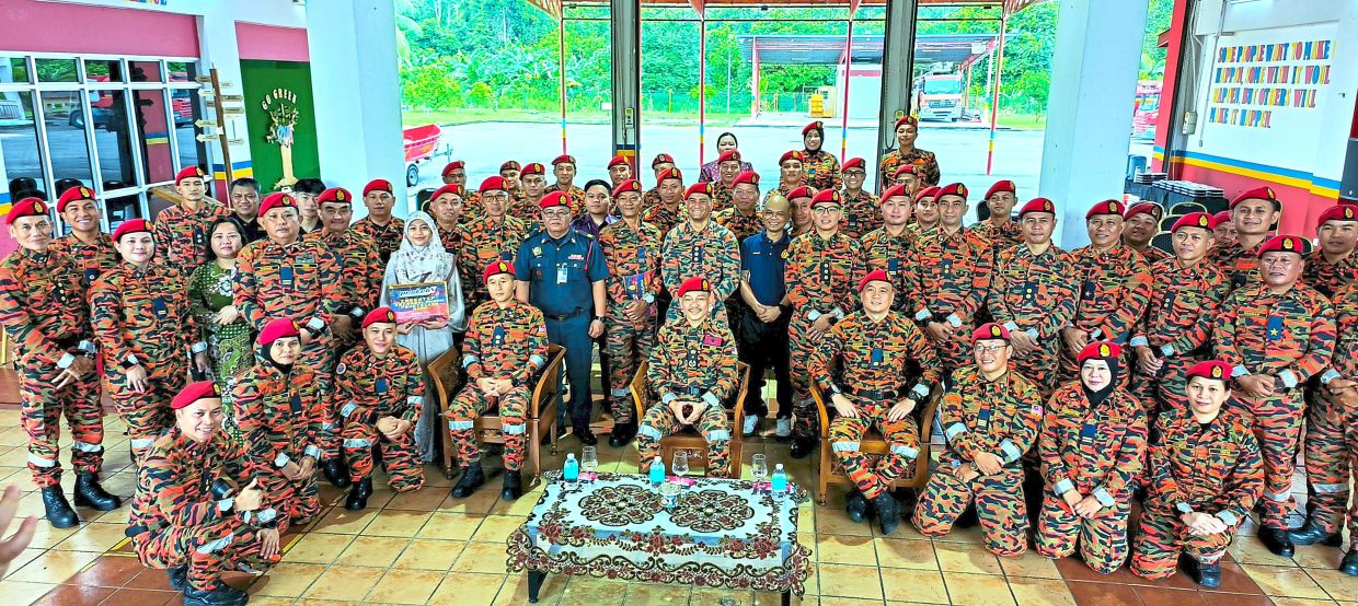 Jamri (seated centre), with Alie (seated on his right), together with firefighters, students and media during the event.