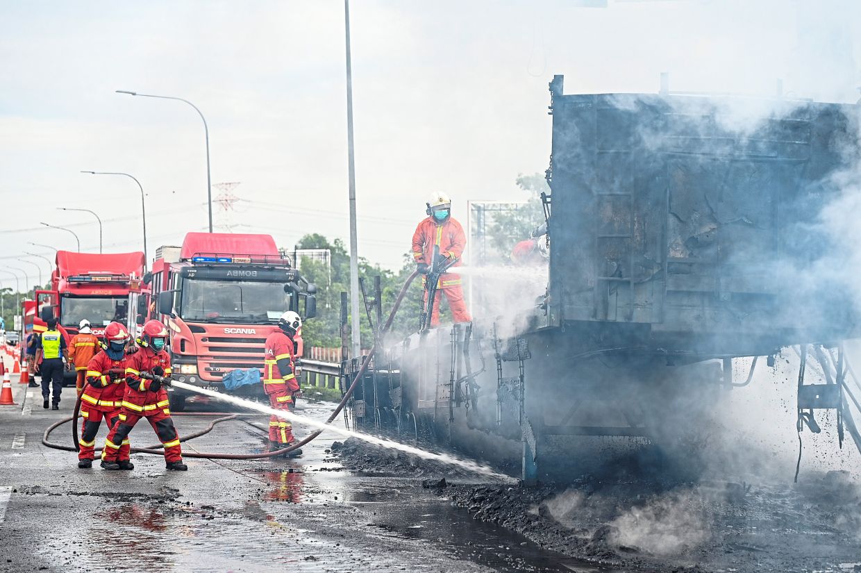 Firefighters extinguishing a lorry fire along Elite expressway in Klang Valley.