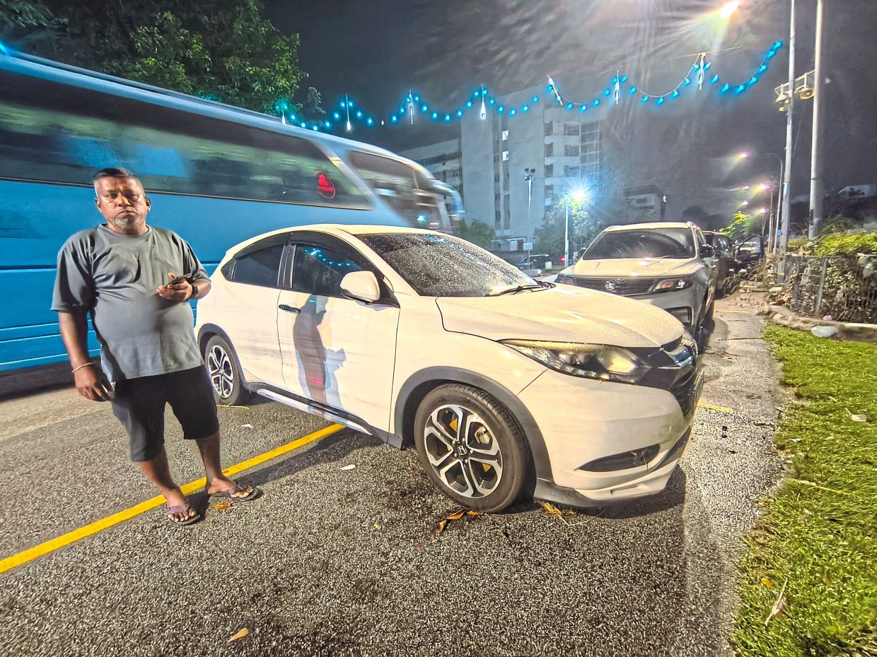 Manivannan waiting for his car to be towed away as the engine could not start after the vehicle was caught in the floods.